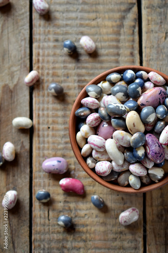 Assortment of young legumes and beans of different varieties and colors in a clay bowl. Raw food. Healthy diet concept. Selective focus