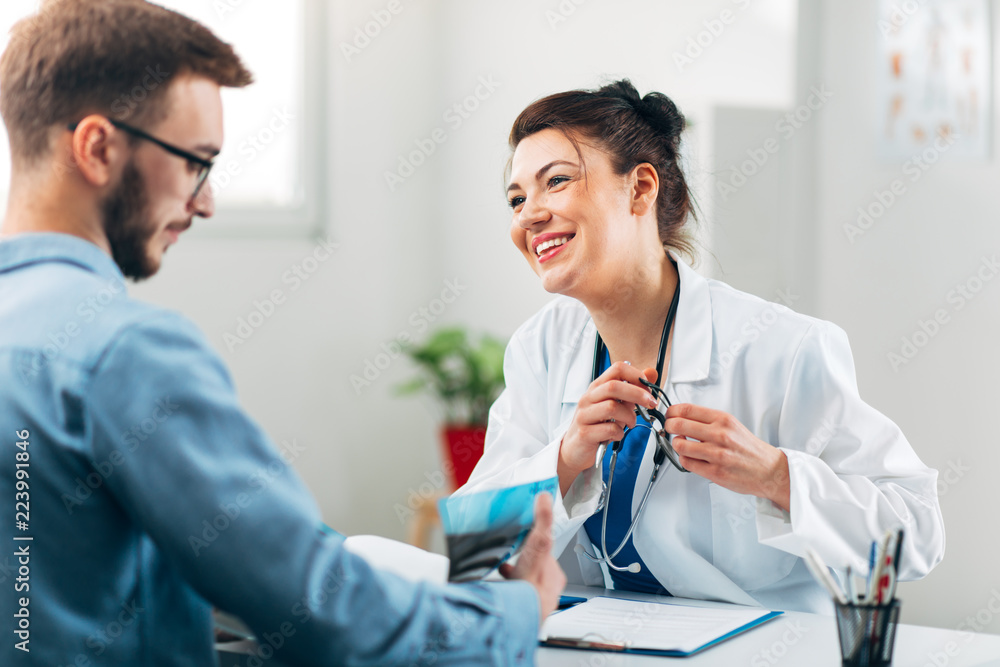 Obraz premium Woman Doctor talking to Patient at her Medical Office