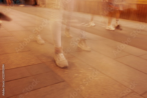 Legs of people in motion on the road as a background