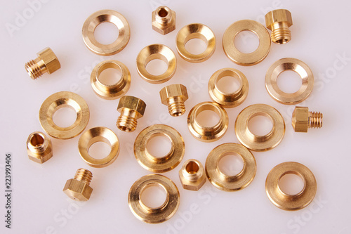 bronze Brass Flat Washers Hardware Gaskets and GIGLEURs, close-up, of different sizes scattered a white background. A nozzle (jet) that is calibrated to injectors