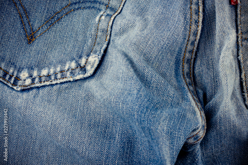old blue jeans seam detail cloth of denim for pattern and classic background close up
