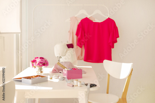 Workplace for sewing and needlework in a bright room with white furniture.