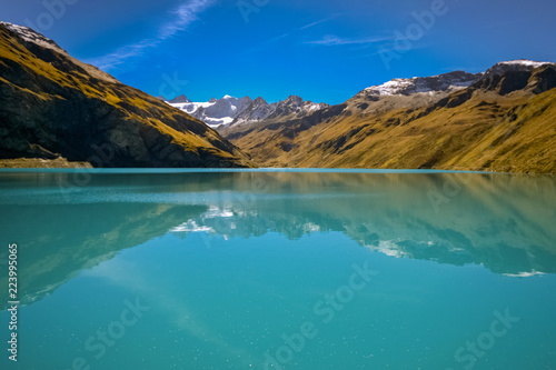 Reflections on the water reservoir of the Lac de Moiry  Valais  Switzerland . It is part of a gravity dam or barrage in the Valley of Grimentz.