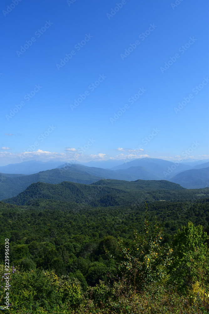 Green mountains and blue sky. Beautiful summer landscape with multilayered hills, fog and forest. Main Caucasian ridge, Adygea. Green mountains and blue sky. Beautiful summer landscape with multilayered hills, fog and forest. Main Caucasian ridge, Adygea.