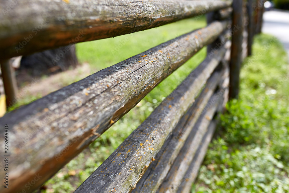 Surface of old wooden sticks arranged herringbone. Wooden fence close up background. Old wooden fence on the sand.