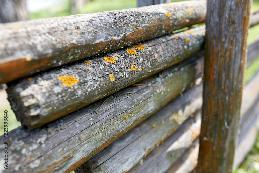 Surface of old wooden sticks arranged herringbone. Wooden fence close up background. Old wooden fence on the sand. Surface of old wooden sticks arranged herringbone. Wooden fence close up background. Old wooden fence on the sand.