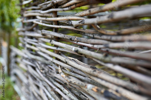 Surface of old wooden sticks arranged herringbone. Wooden fence close up background. Old wooden fence on the sand.