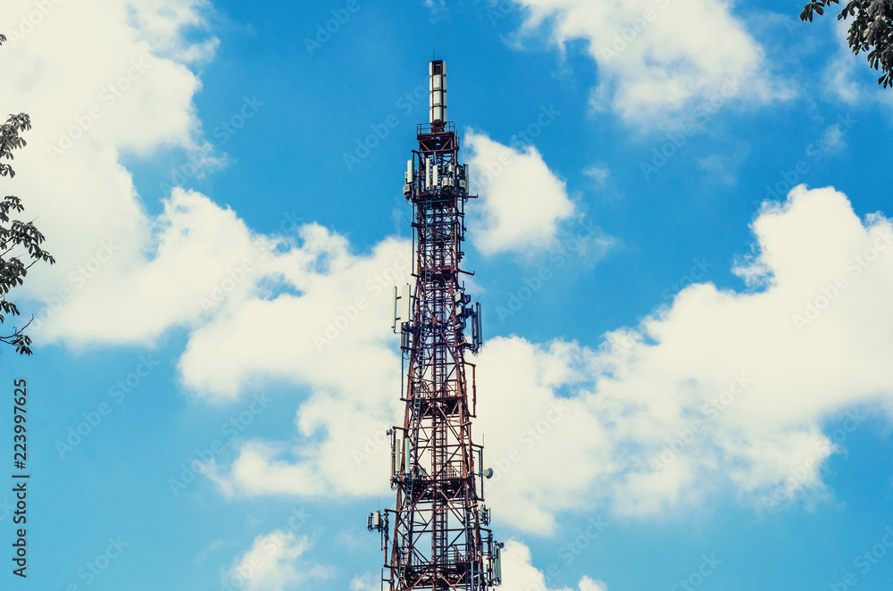 Telecommunication tower with mobile communication antennas on a background of clouds, sky