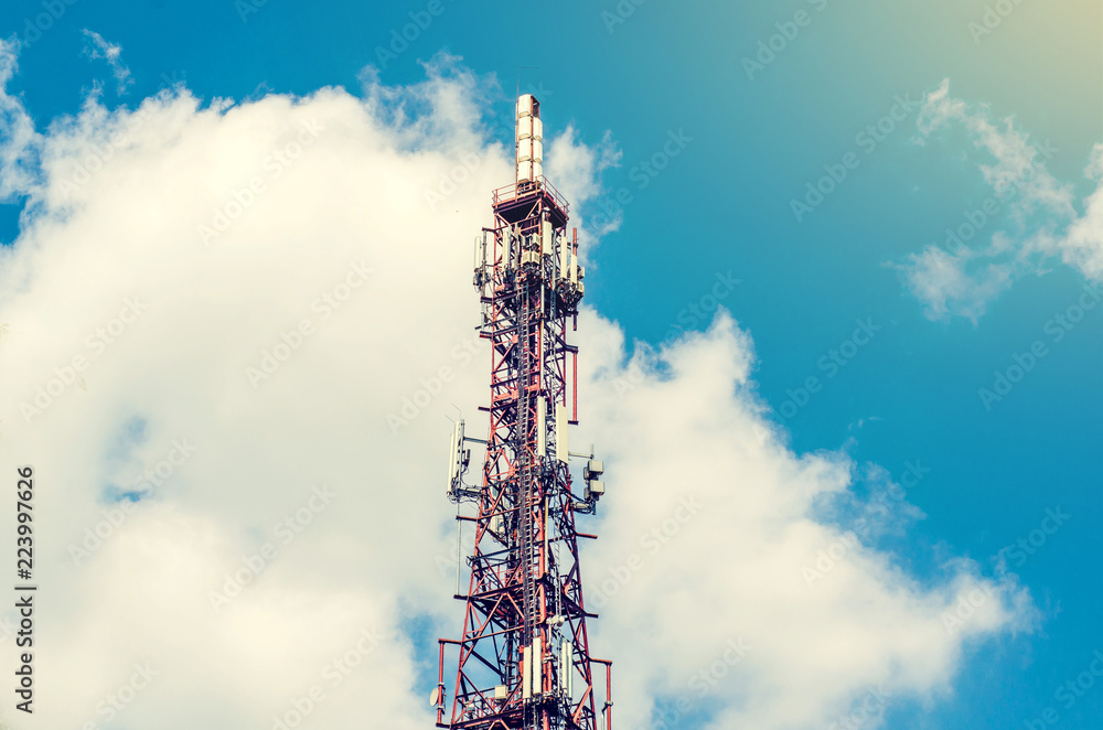 Telecommunication tower with mobile communication antennas on a background of clouds, sky