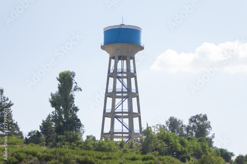 Water tower painted blue under blue sky