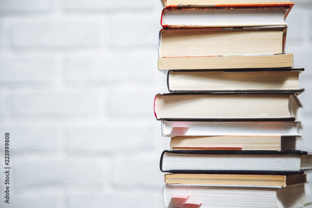 Fototapeta premium Stack of hardback books on wooden table. Back to school. Copy space for text