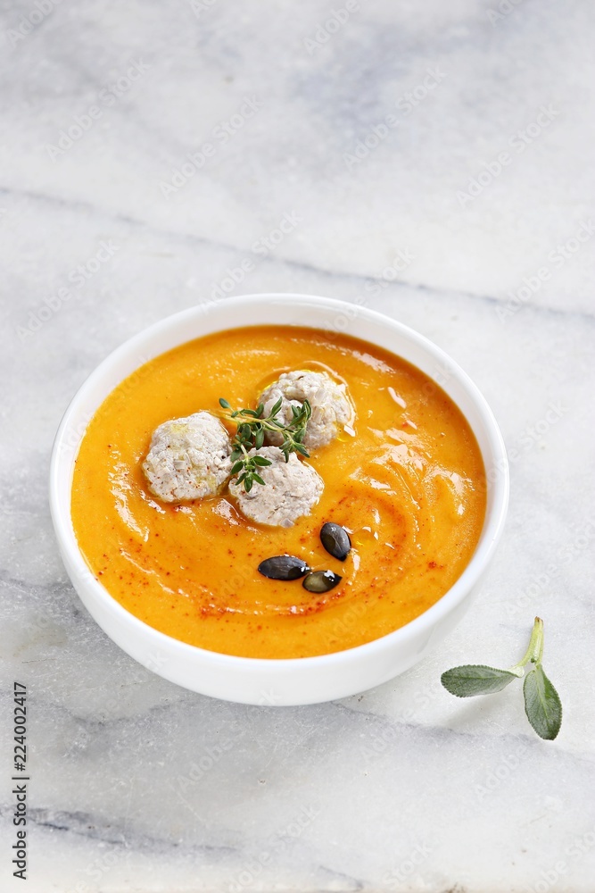 Pumpkin soup with meat balls and pumpkin seeds topping. Copy space
Pumpkin soup with meat balls and pumpkin seeds topping. Copy space