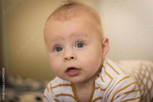 Portrait of a expressive happy baby, holds head up. baby development concept photo, lifestyle