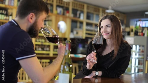 A young man and a girl are drinking wine at a table in a restaurant, a man and a woman are drinking red wine in glasses, a restaurant interior, interior wine restaurant, a male hipper photo
