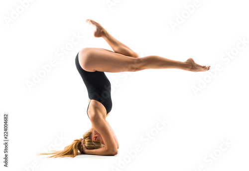 Young blonde woman in maillot practicing rhythmic gymnastics
