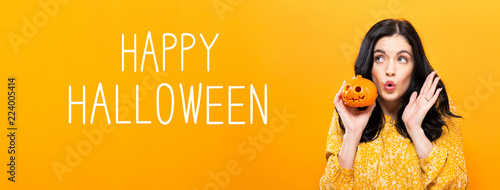 Happy Halloween with young woman holding a pumpkin