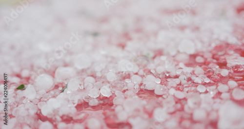 Tableau sur toile closeup of hailstones on red car after strong hailstorm