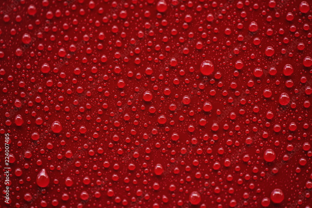Fototapeta premium Zbliżenie krople deszczu na czerwonym samochodzie z powłoką hydrofobową