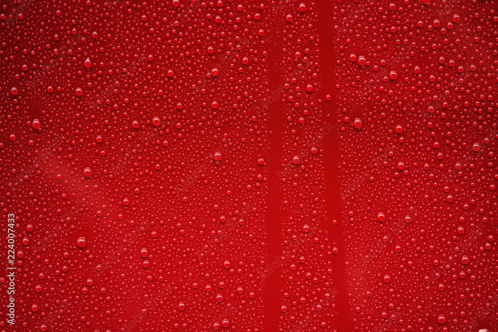 Fototapeta premium Closeup rain drops on red car with hydrophobic coating