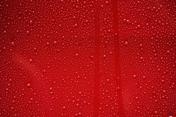 Closeup rain drops on red car with hydrophobic coating