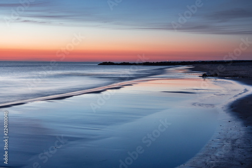 Fototapeta Letniej nocy słońca plaży kolorowe światło na duńskiej plaży w spokojny wieczór z nieba odbicie na mokrym piasku. Lønstrup w Północnej Jutlandii w Danii, Skagerrak, Morze Północne