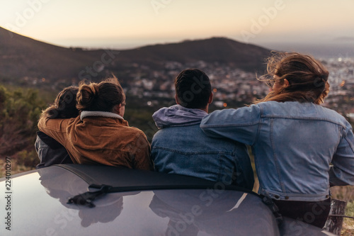 Friends looking at the city from a road on top of a hill