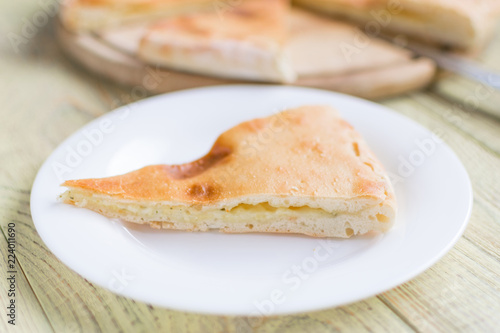 Pie with cheese, khachapuri on a wooden background.