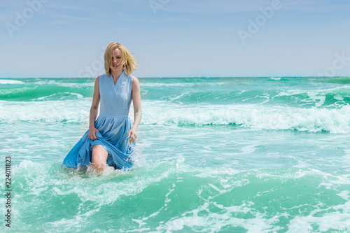 Woman in blue dress in the water in the ocean, the sea.