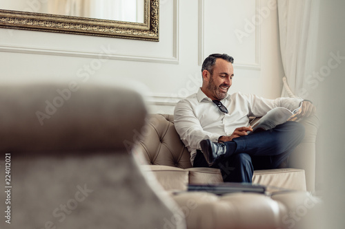 Businessman reading a magazine in hotel room
