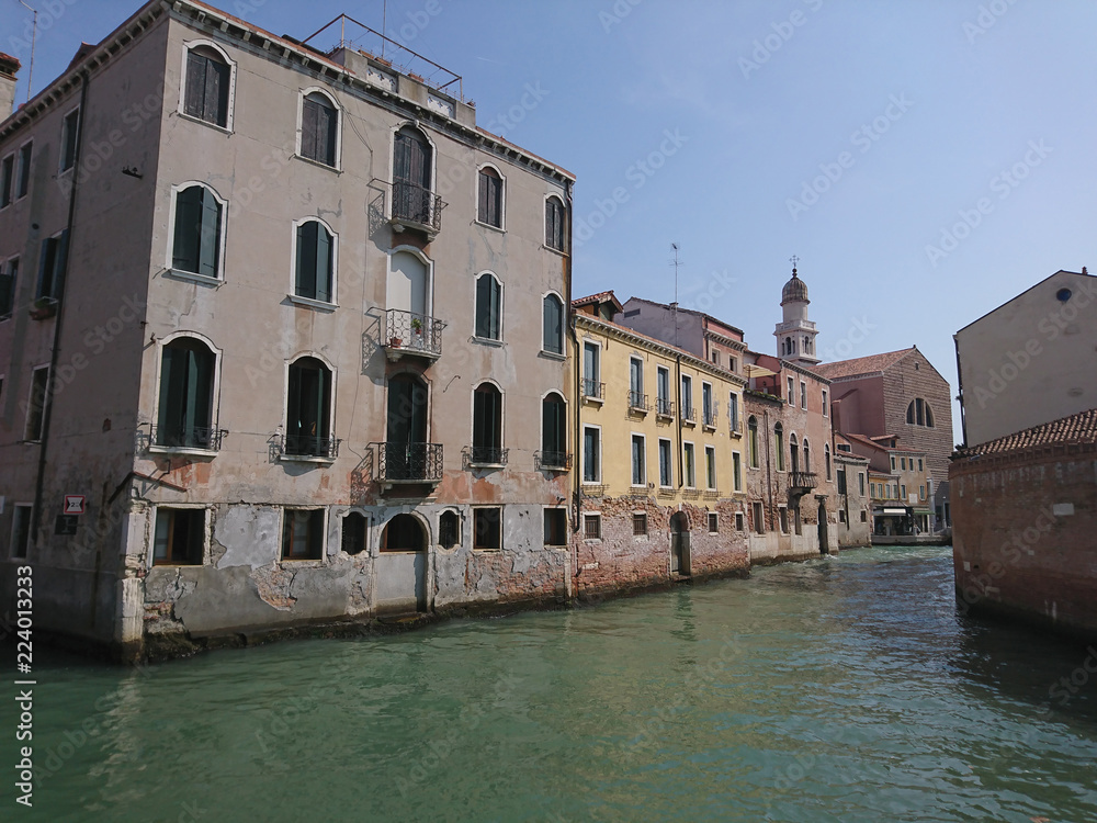 Naklejka premium Widok na historyczną architekturę i kanał między antycznymi budynkami w Wenecja, Włochy podczas radosnych wakacji w słonecznym dniu.