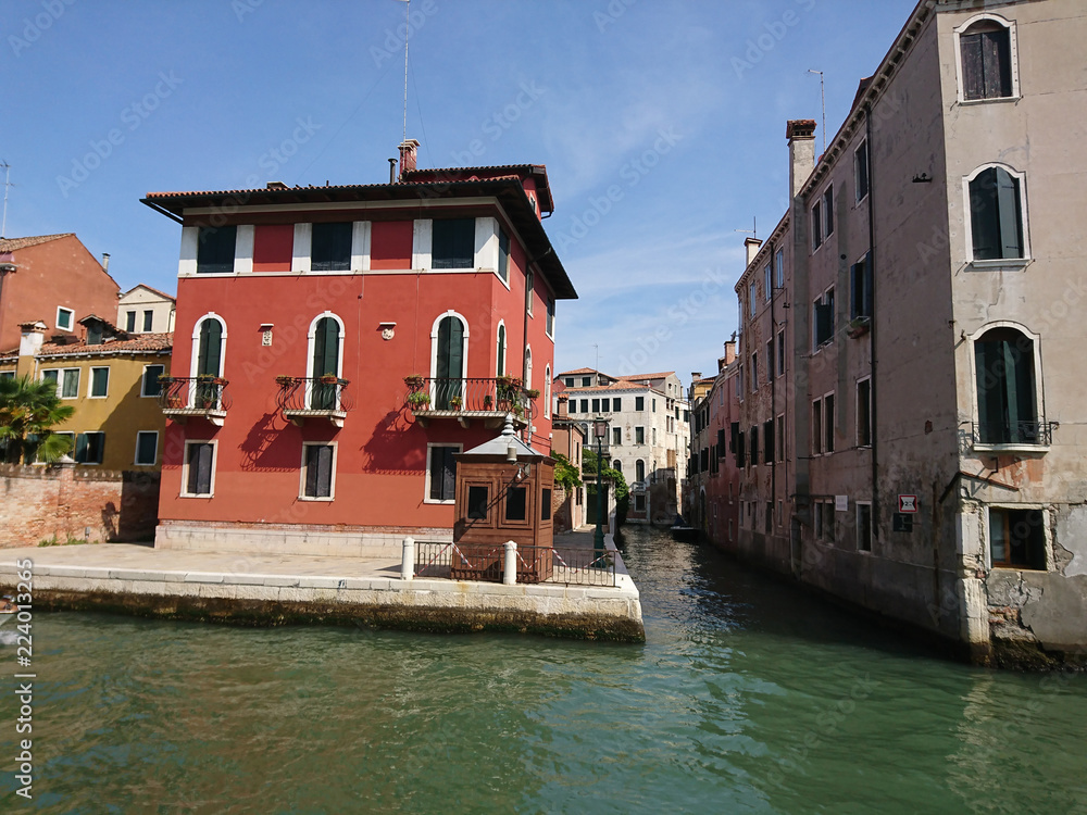 Naklejka premium Widok na historyczną architekturę i kanał między antycznymi budynkami w Wenecja, Włochy podczas radosnych wakacji w słonecznym dniu.