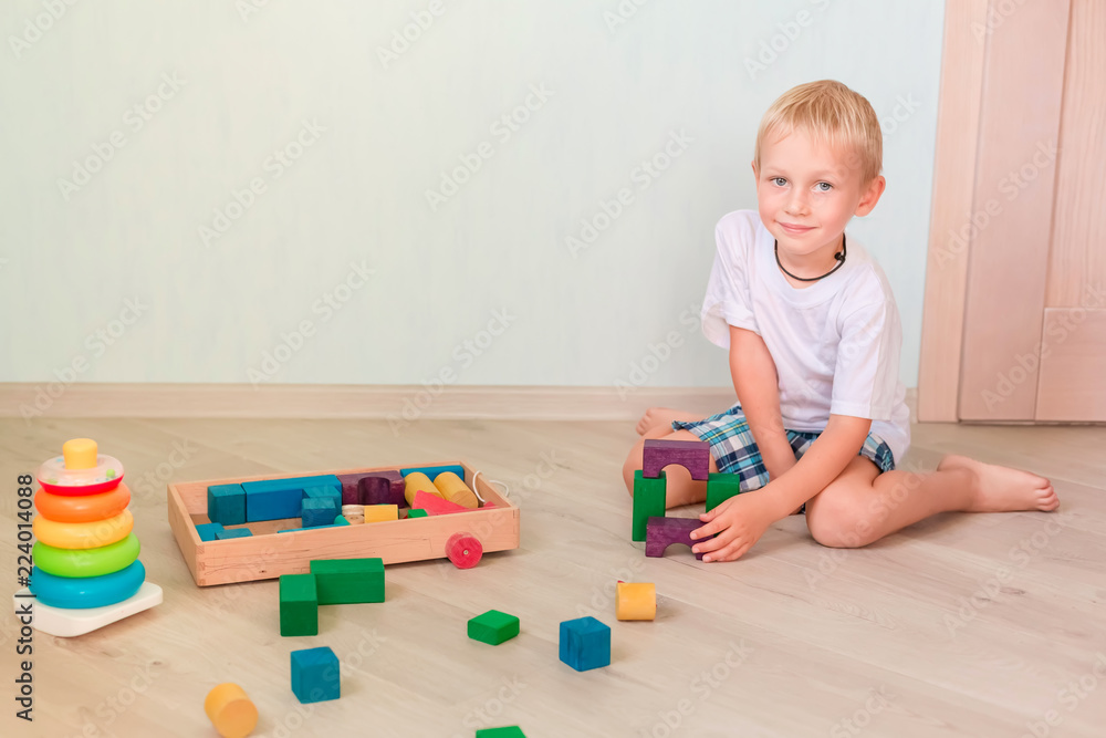 Cute little boy playing with colored wooden blocks Cute little boy playing with colored wooden blocks