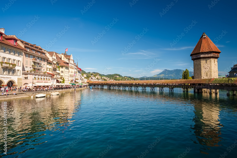 The famous Chapel Bridge (Kapellbrucke) and Water Tower (Wasser Turm) in Lucerne (Luzern), Switzerland. The bridge crosses the river Reuss which debouches into the Lake Lucerne (Vierwaldstattersee). 