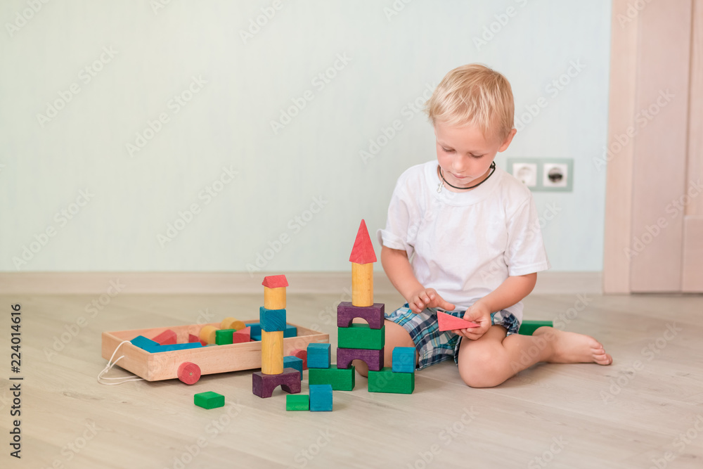 Cute little boy playing with colored wooden blocks Cute little boy playing with colored wooden blocks