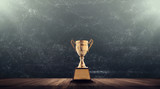 champion golden trophy placed on wooden table with blackboard background copy space ready for your design win concept..