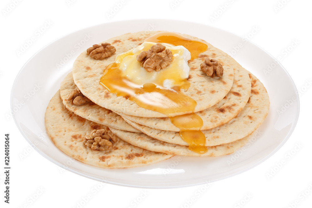 Cakes with sour cream, honey and nuts on a plate. Isolated on white background.