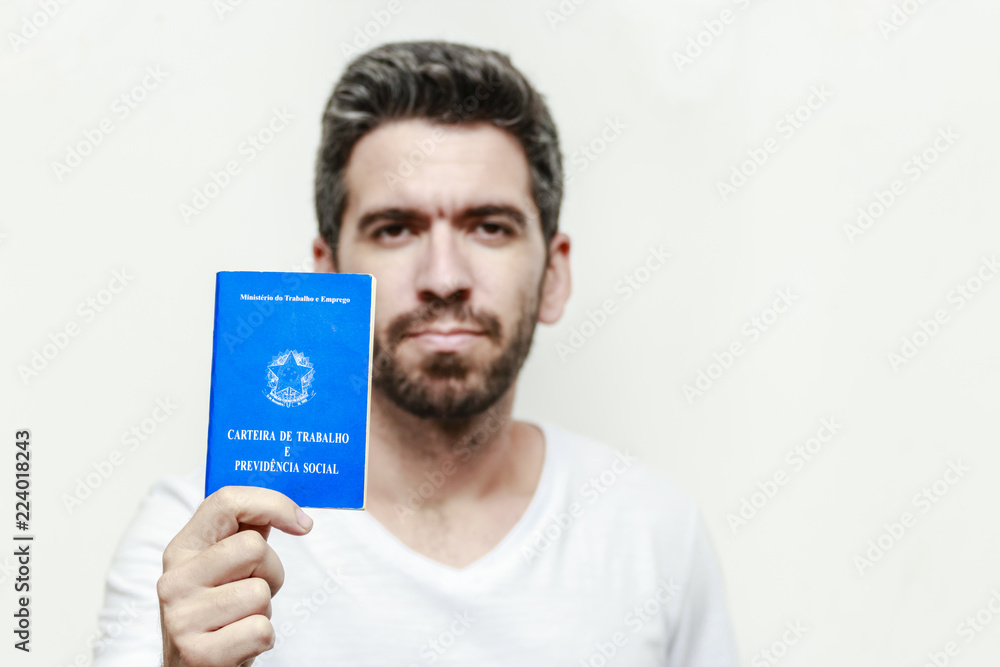 Brazilian man with document work and social security, (Carteira de Trabalho e Previdencia Social) on white background Brazilian man with document work and social security, (Carteira de Trabalho e Previdencia Social) on white background