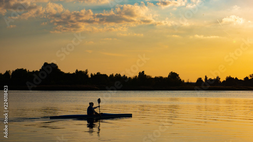 Woman canoeing at sunset on Vistula river, Poland.