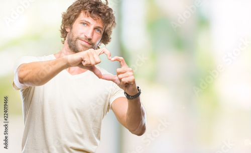 Handsome hispanic model man over isolated background smiling in love showing heart symbol and shape with hands. Romantic concept.