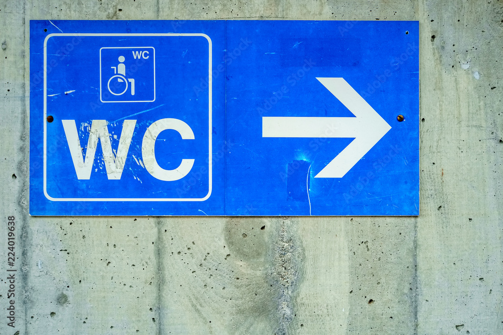 Foto de A blue sign against a concrete wall is indicating where the