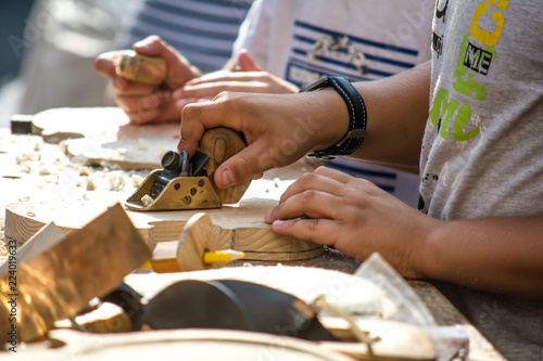 Children learn to make custom violin and other musical instruments in outdoor fablab classes. Joiner's training on makerfaire. photo