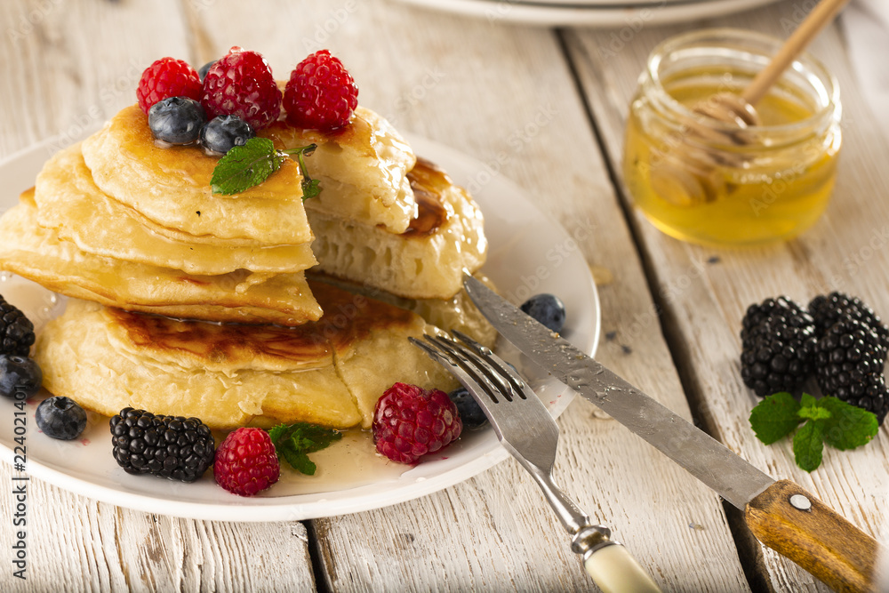 Pancakes with forest fruits berries on white table. Pancakes with forest fruits berries on white table.