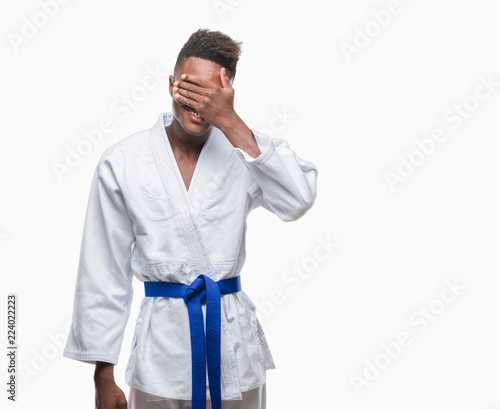 Young african american man over isolated background wearing kimono smiling and laughing with hand on face covering eyes for surprise. Blind concept. © Krakenimages.com