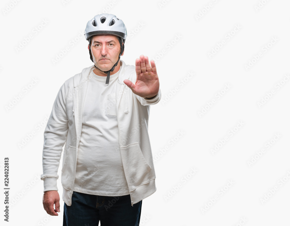 Handsome senior cyclist man wearing bike helmet over isolated background with open hand doing stop sign with serious and confident expression, defense gesture Handsome senior cyclist man wearing bike helmet over isolated background with open hand doing stop sign with serious and confident expression, defense gesture