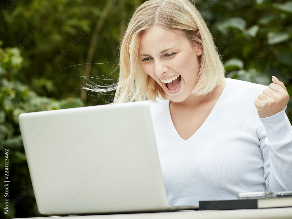 Junge blonde Frau arbeitet im grünen Homeoffice Junge blonde Frau arbeitet im grünen Homeoffice
