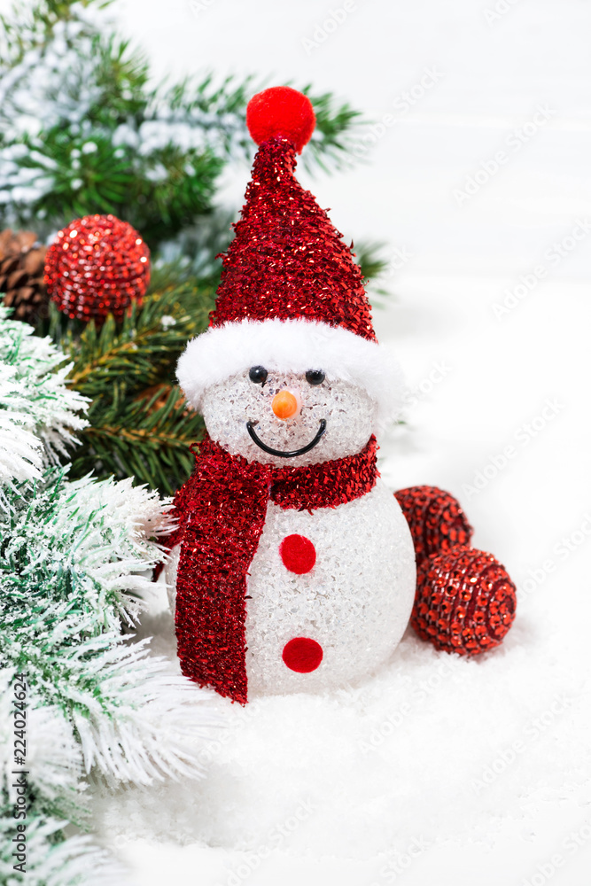 christmas snowman in fir branches on a white background, vertical christmas snowman in fir branches on a white background, vertical