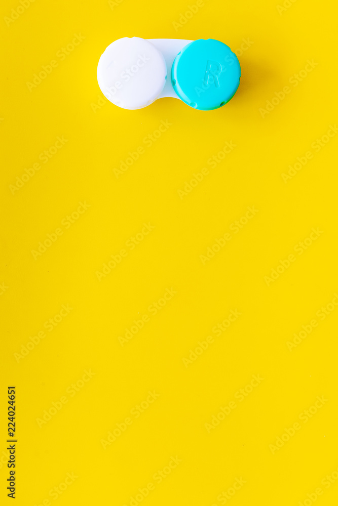 Improve vision concept. Contact lenses in container on yellow background top view copy space Improve vision concept. Contact lenses in container on yellow background top view copy space