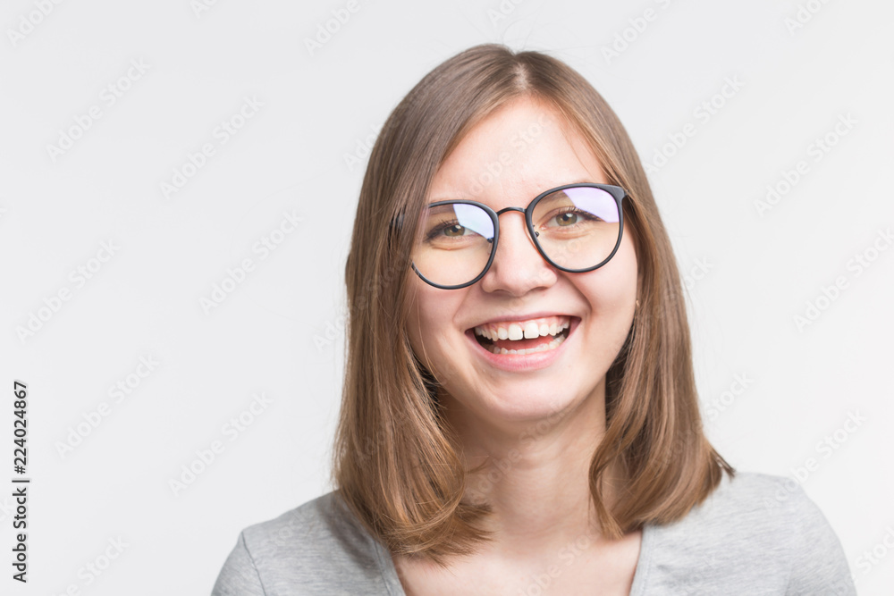 Portrait of laughing happy brown hair girl in a glasses over white background