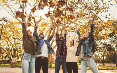Friends having fun throwing leaves in the air