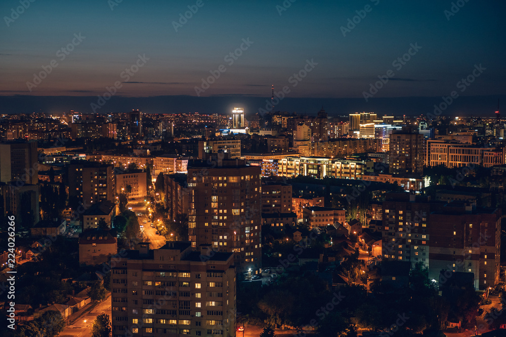 Aerial view of night city with buildings, malls and roads with traffic, skyline downtown panorama